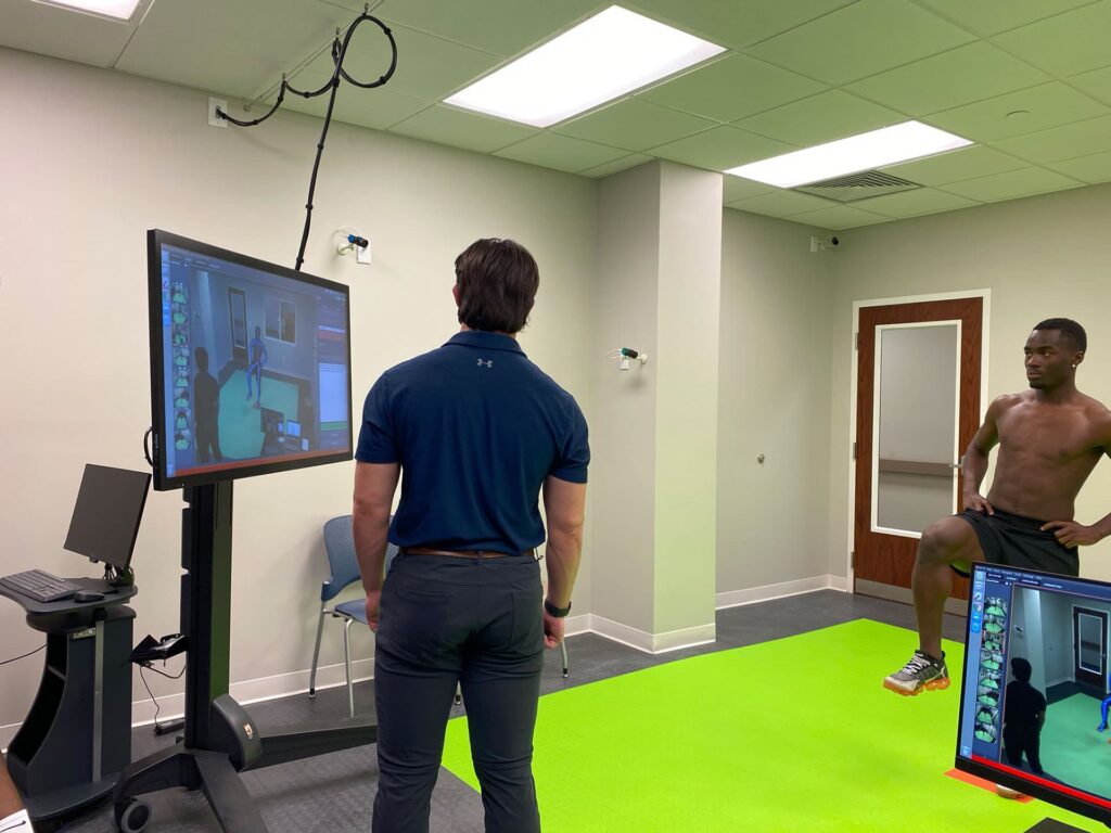 An SBO staff member helping a patient using the 3D performance lab